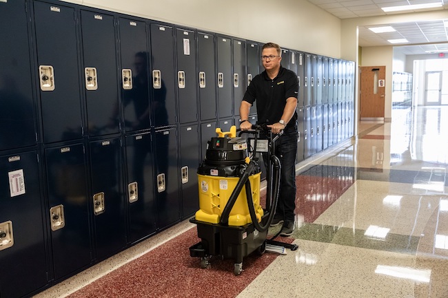 Custodial worker using an autovac. Courtesy of Kaivac. 