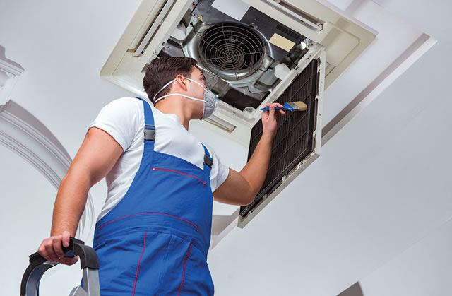 man cleaning ventilation screen