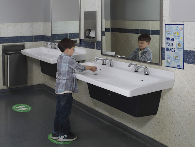 Student washing hands with touchless faucet. 