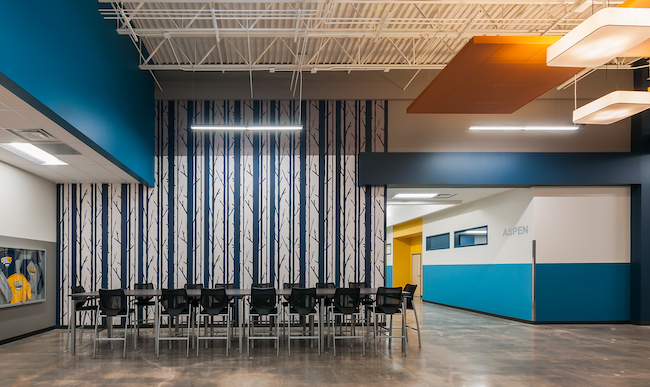The volume of the existing structure of CEC Fort Collins High School offered an opportunity to bring daylight in from above, creating a community space within the hallway.