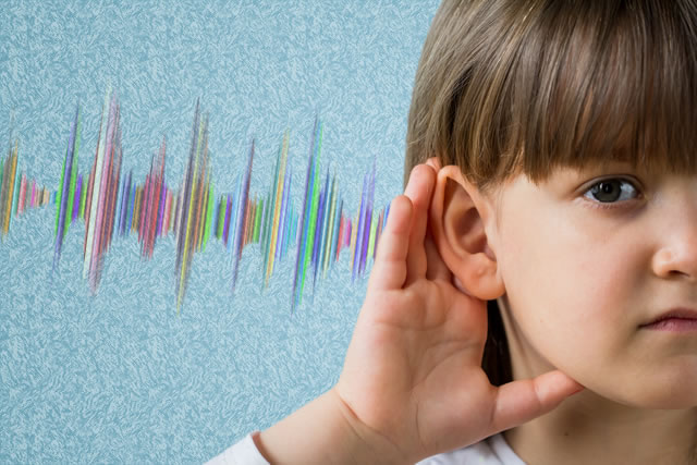 young girl holding cupping her hand around her ear to hear